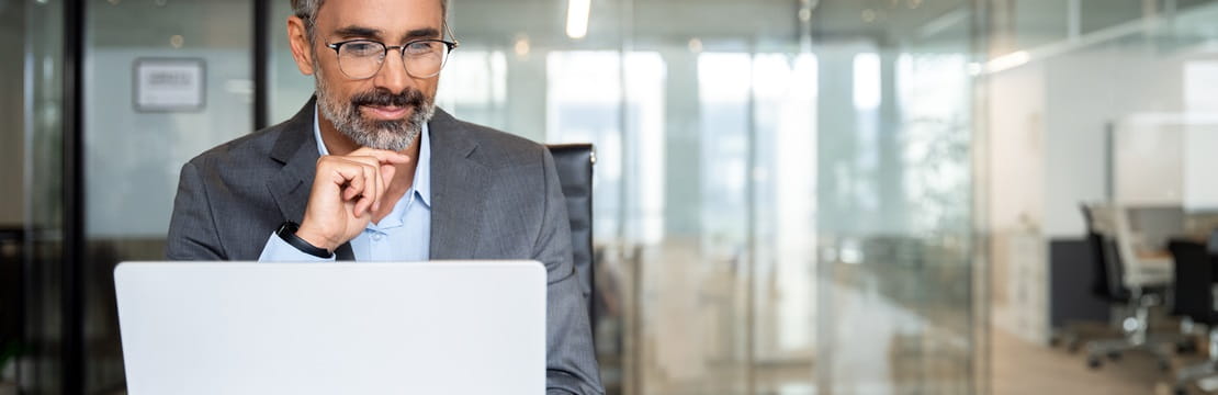 Businessman focusing on his laptop while seated in an office.